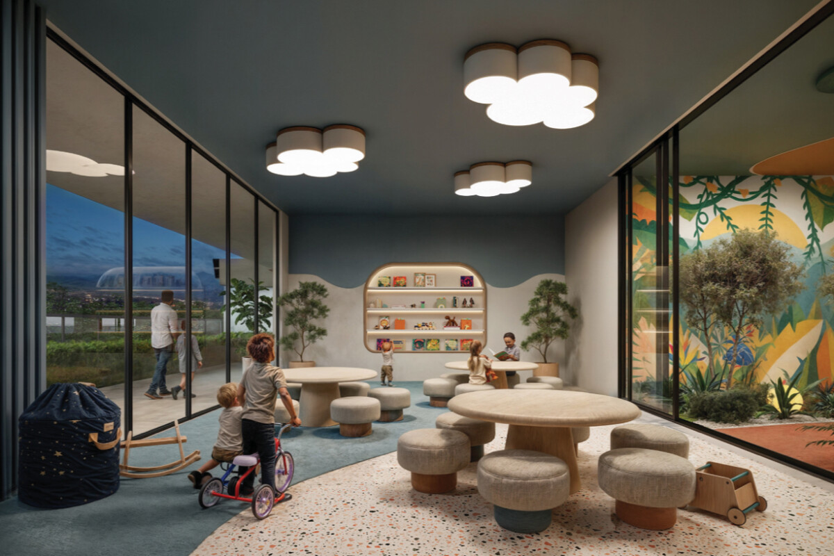 "Bright children's learning center at Montbleu Westlands with colorful wall mural, natural light, interactive play areas, shelving, cloud ceiling lights, and nature-inspired design"